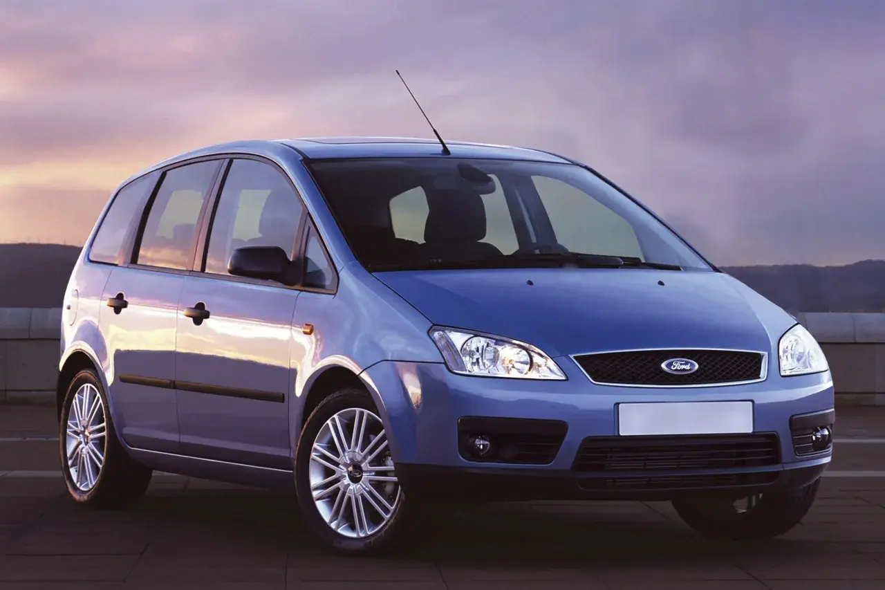 Niebieski Ford Focus C-Max z 2004 roku stoi na tle zachodzącego słońca.