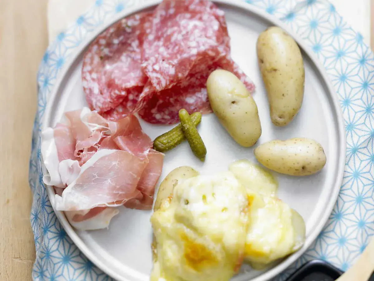 Assiette de raclette sans appareil : pommes de terre gratinées, charcuterie, cornichons. Un délice !