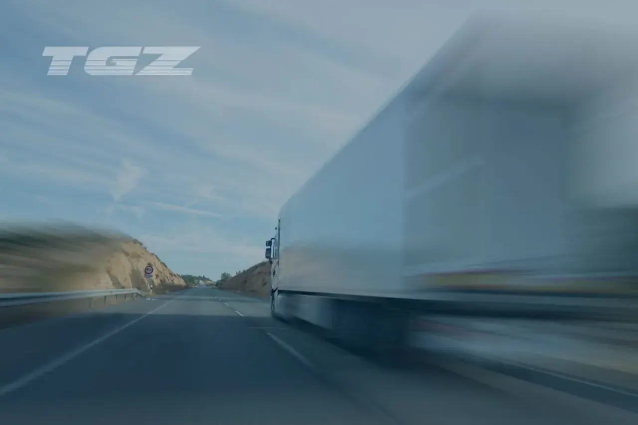 art 12 561 we 2006 opis. Ciężarówka TGZ pędzi autostradą, krajobraz rozmyty przez prędkość.