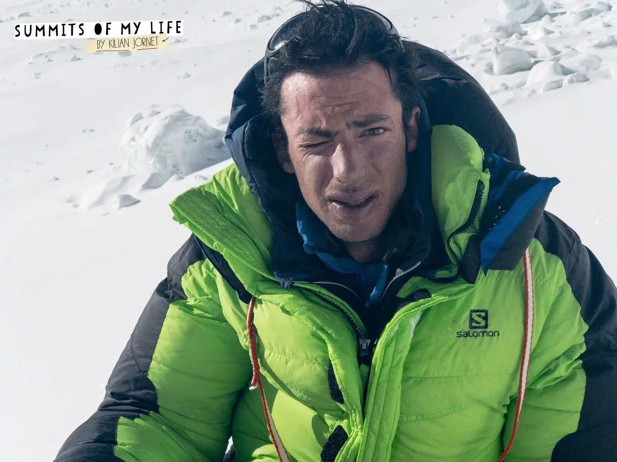 Kilian Jornet, con su chaqueta verde brillante, guiña un ojo en la cima del Everest.
