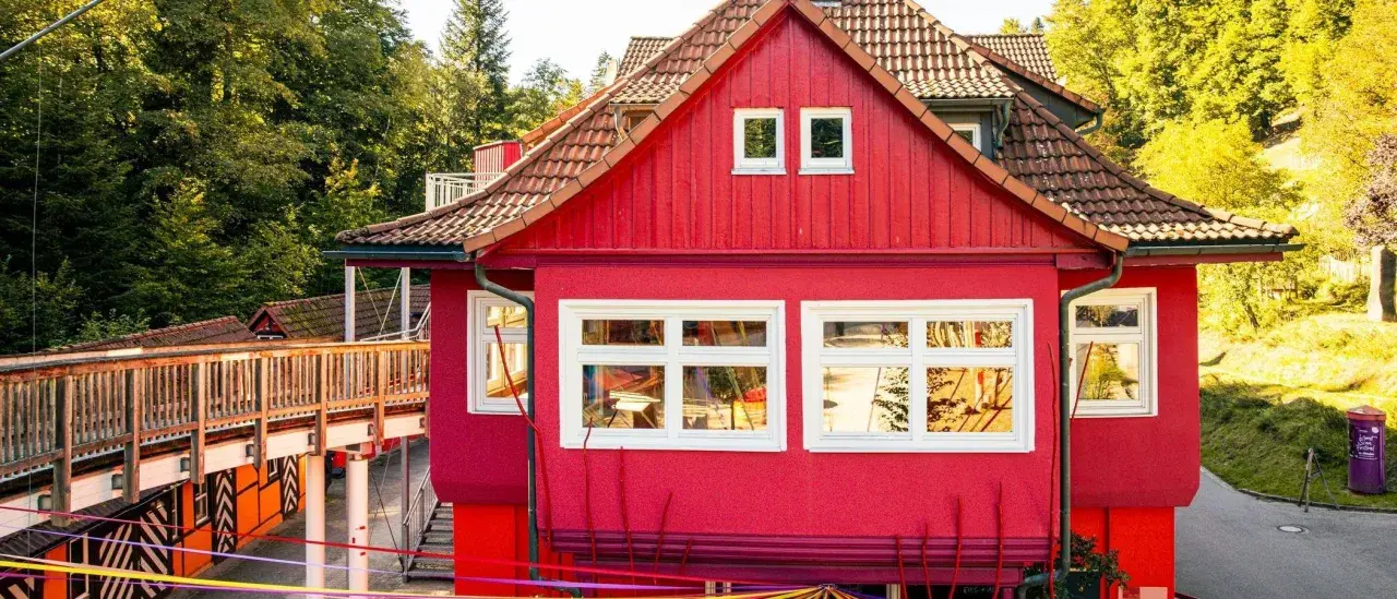 Ein leuchtend rotes Haus mit Holzbrücke und bunten Bändern. Hier gibt es Spaß für eins und alles ab welchem Alter.