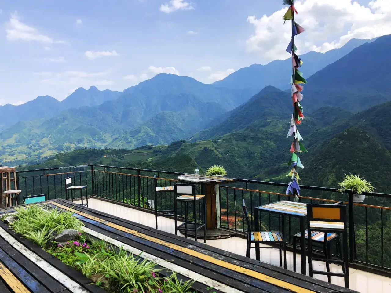 Balkon mit Tischen und Stühlen in Sapa, Vietnam, bietet einen atemberaubenden Blick auf grüne Berge.
