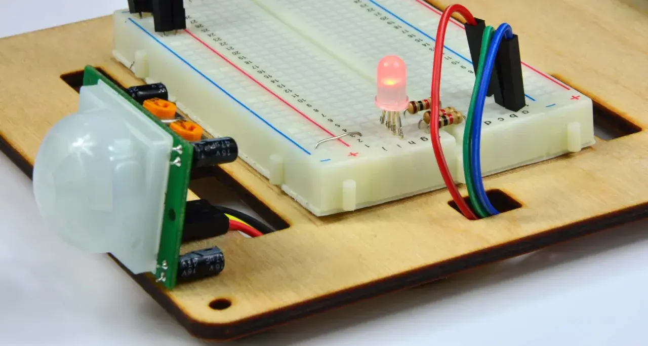 Czujnik ruchu PIR połączony z płytką styków i świecącą diodą LED. Ten kontaktron w oknie jest częścią projektu elektronicznego.