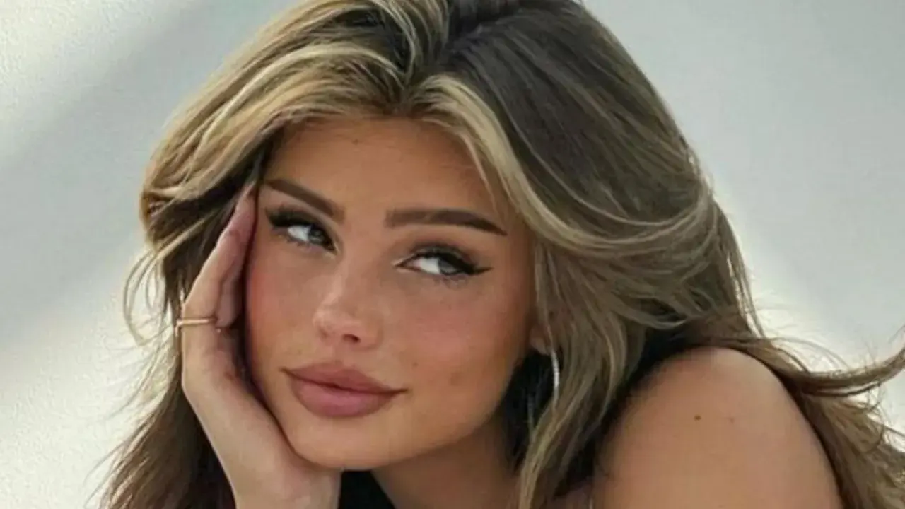 Primer plano de una joven con cabello castaño y reflejos rubios, con sus baby hairs peinados hacia atrás.