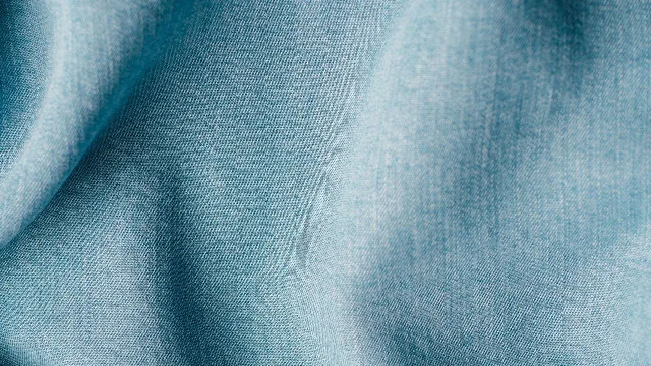 Blaues Lyocell-Gewebe mit feiner Webstruktur. Es ist lyocell elastisch und fühlt sich weich an.