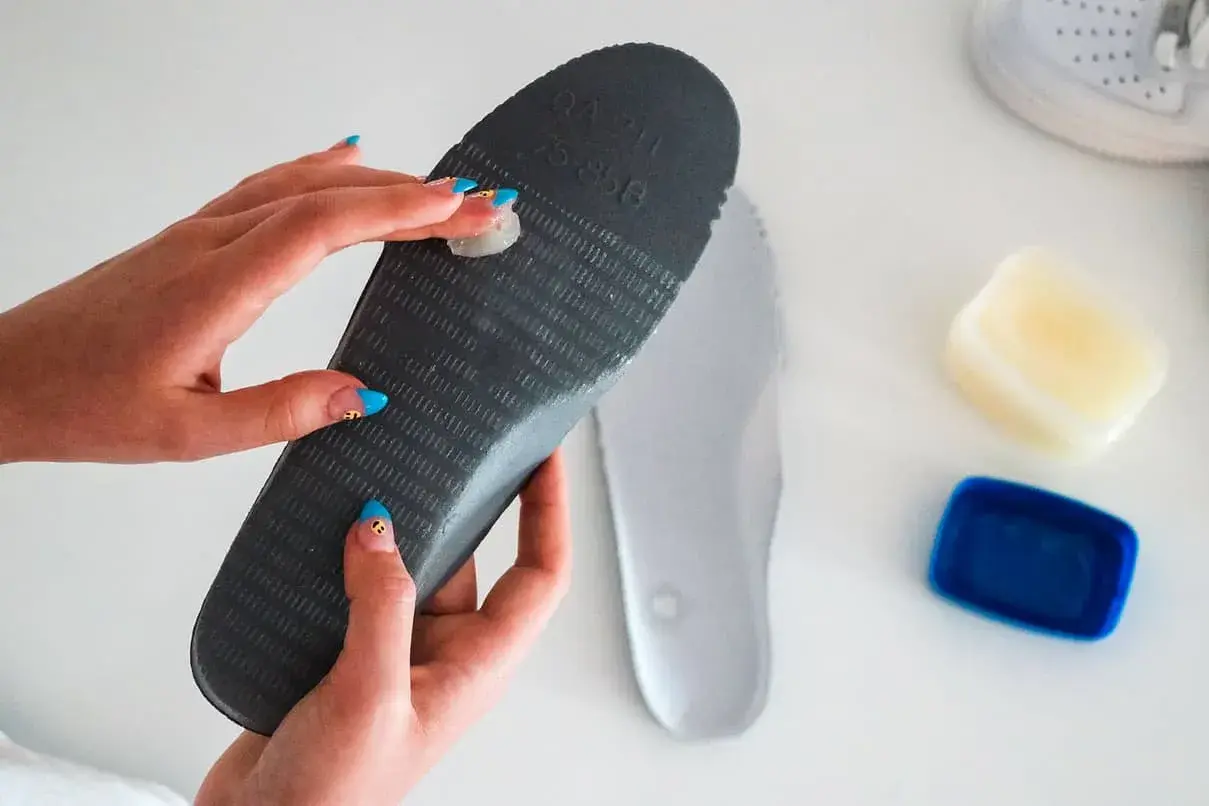 Applying balm to an insole to stop slides from squeaking.