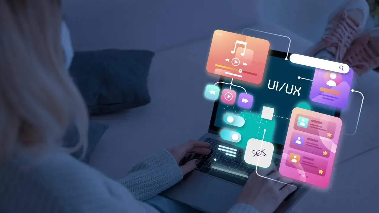 Persona trabajando en el diseño web de una aplicación, con elementos de UI/UX flotando sobre la pantalla.