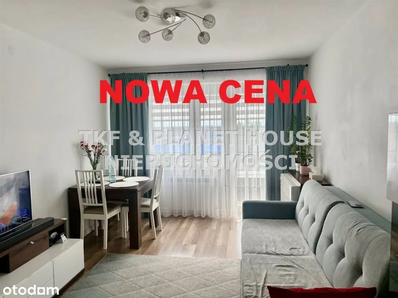 Nowa cena nieruchomości! Salon z jadalnią, kanapą i stołem. Okna z zasłonami.