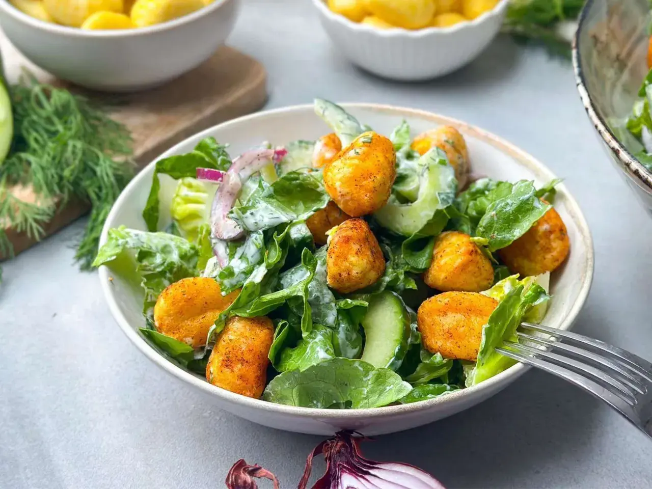 Knuspriger Gnocchi Salat mit Gurken, Zwiebeln und cremigem Dressing. Ein leckeres Gericht für jede Gelegenheit.