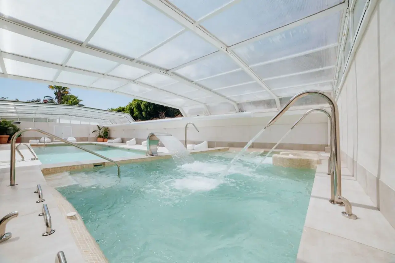 Piscinas termales cubiertas con chorros de agua y cascadas, perfectas para relajarse en el camping Alannia Guardamar.