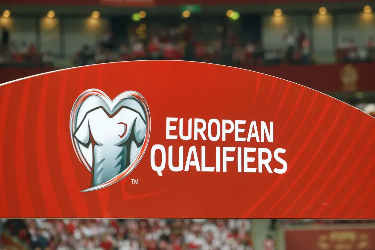 Czerwony baner z napisem "EUROPEAN QUALIFIERS" i symbolem koszulki w sercu. To część rozgrywek eliminacyjnych do Mistrzostw Europy.