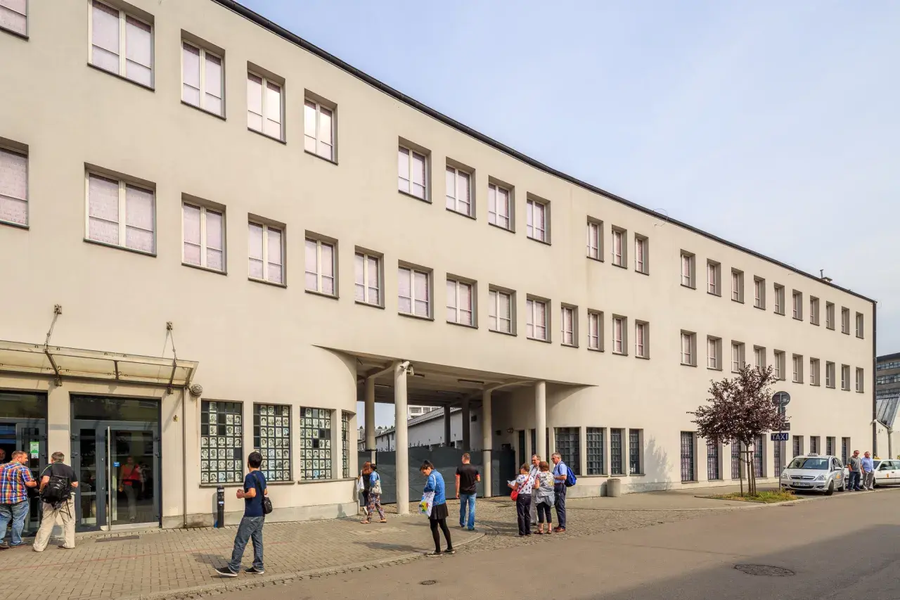 Dawna fabryka Oskara Schindlera w Krakowie, dziś muzeum. Na fasadzie widoczne okna i wejście, przed którym stoją ludzie.