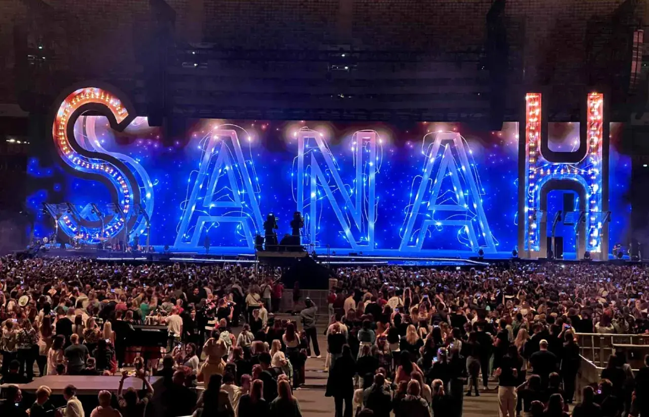 Koncert sanah w Warszawie. Ogromny napis SANAH na scenie, tłum fanów z telefonami w górze.
