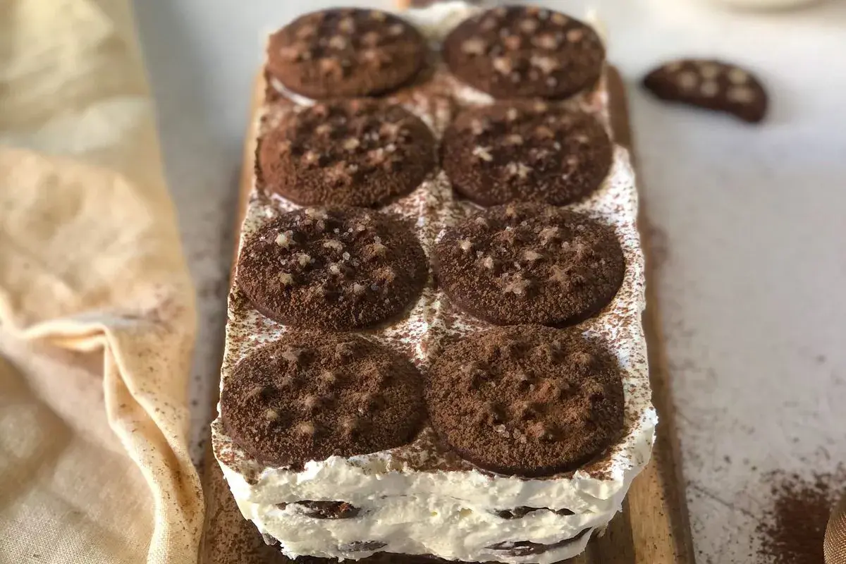 Deliziosa torta pan di stelle, stratificata con crema e biscotti al cacao, spolverata di cacao amaro.