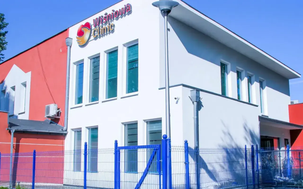 Nowoczesny budynek kliniki Wiśniowa Clinic w Zielonej Górze z niebieskim ogrodzeniem.