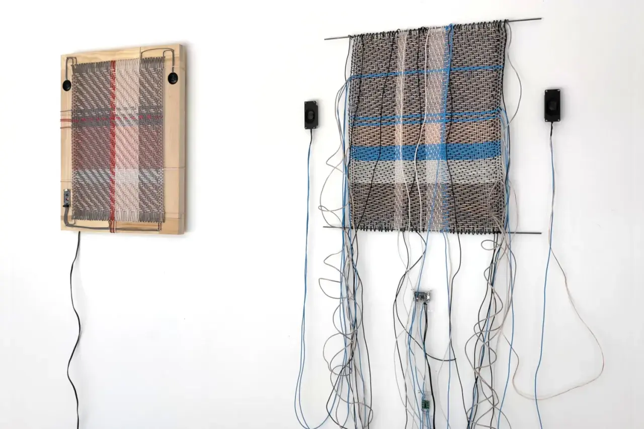 Deux œuvres d'art de tissage dessin, ornées de fils et de câbles, sont accrochées à un mur blanc.