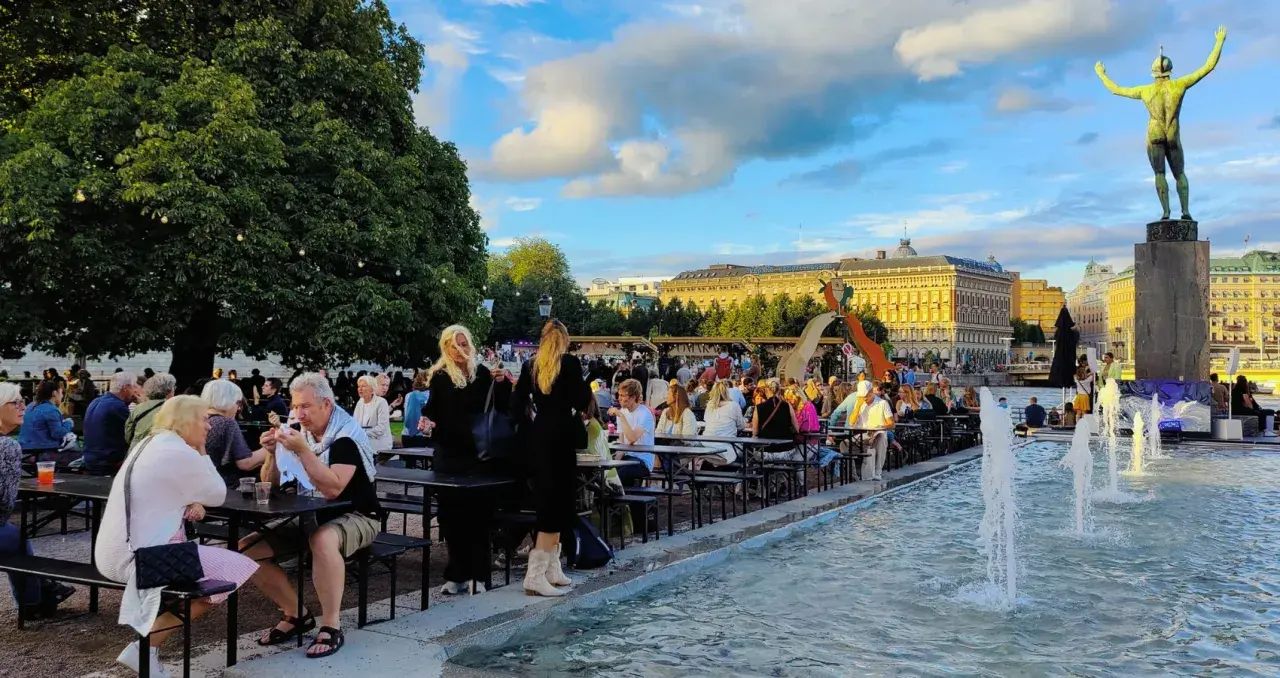 Folk njuter av sommarkvällen vid fontänen, en del av programmet för kulturfestivalen.