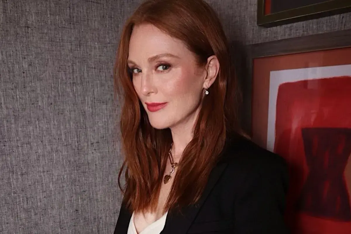 Eleganckie stylizacje do rudych włosów: Julianne Moore w czarnej marynarce i z subtelną biżuterią.