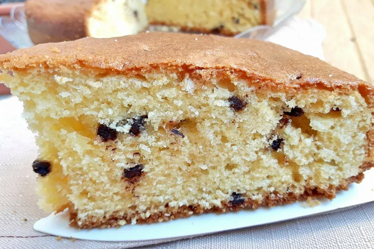 Una fetta soffice di torta con mascarpone e gocce di cioccolato, con la crosticina dorata e l'interno morbido e profumato.