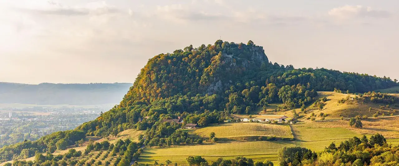 Burgruine Hohenzollern, ein Wahrzeichen Deutschlands, thront auf einem bewaldeten Berg. Die Landschaft um Singen, Deutschland, ist im Herbstlicht malerisch.