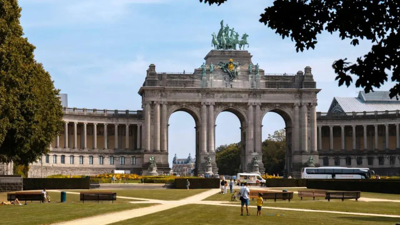 Łuk Triumfalny w Parku Cinquantenaire, Bruksela. W tle widać budynki muzealne i autokar, symbolizujący komunikację miejską Brukseli.