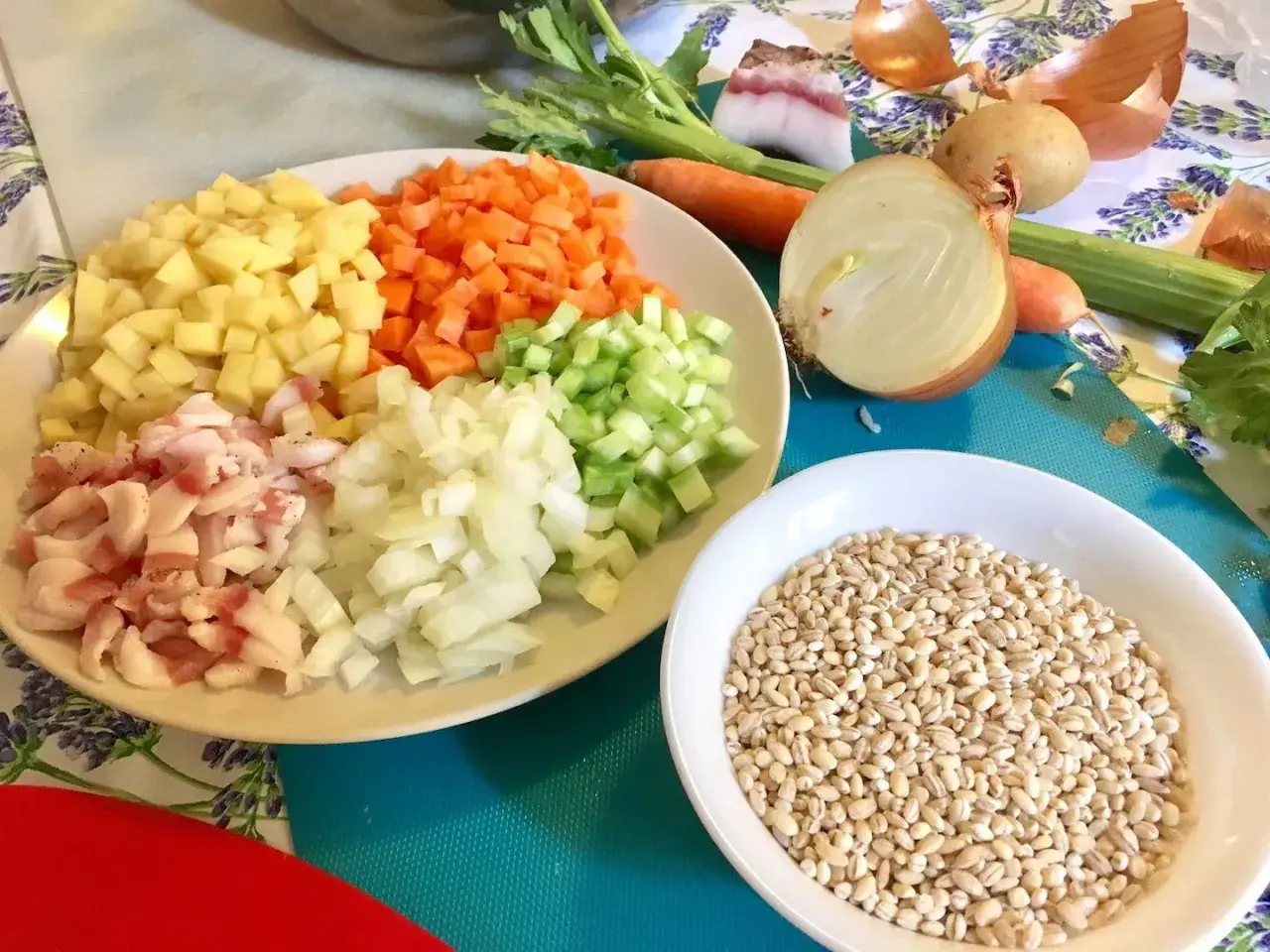 Ingredienti pronti per una saporita minestra d'orzo: orzo perlato, patate, carote, sedano, cipolla e pancetta.