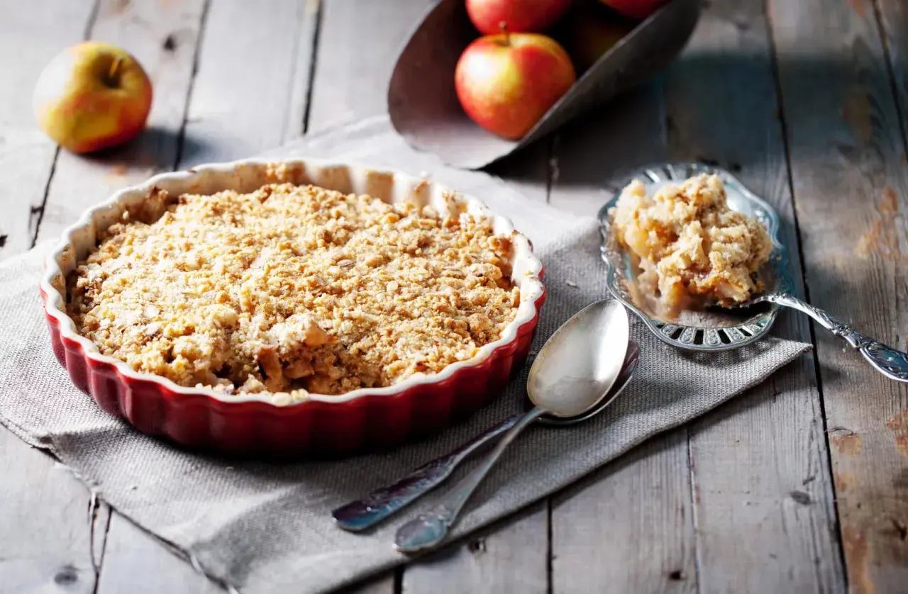 Un délicieux crumble pomme tout juste sorti du four, prêt à être dégusté. Des pommes fondantes sous une couche croustillante.