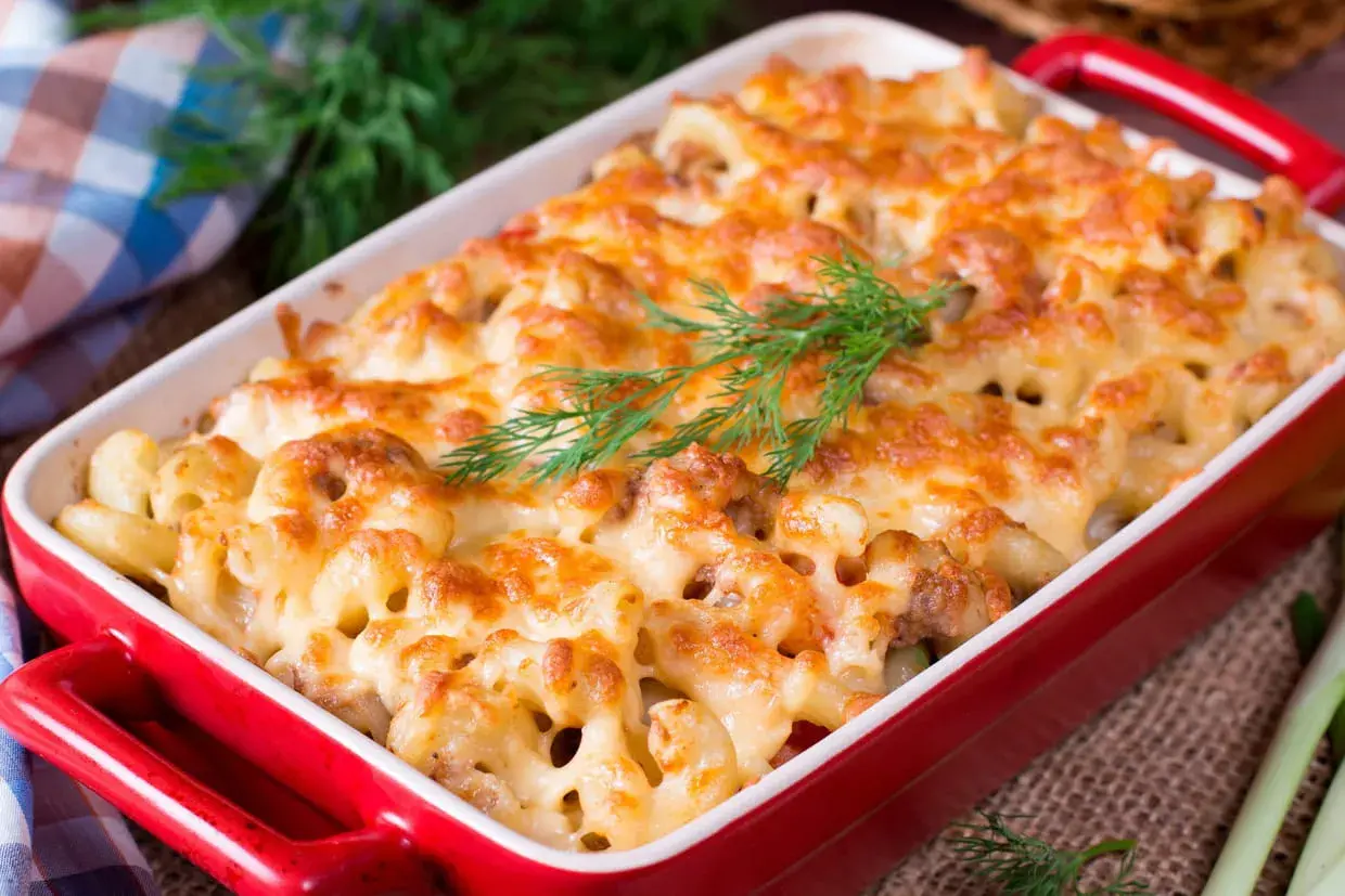 Un plat de pâtes au four gratinées, garni d'une touche d'aneth frais. Un délice réconfortant prêt à être dégusté.