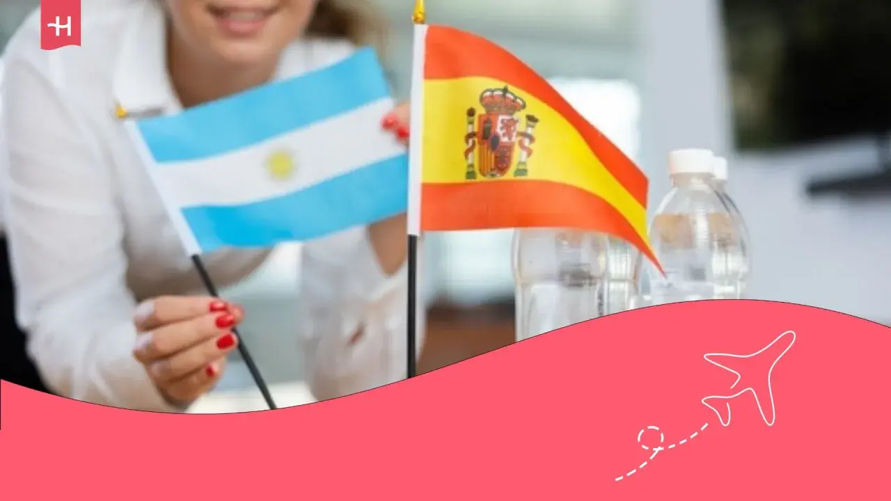 Persona sonriente sostiene banderas de Argentina y España. ¡Una oportunidad para un working holiday!