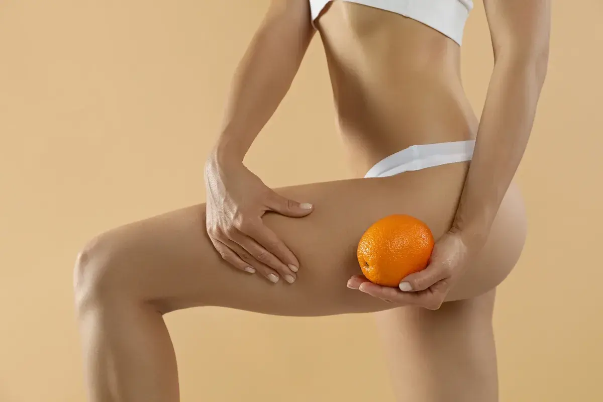 Gambe toniche e una mano che tiene un'arancia, un'immagine che evoca la ricerca di soluzioni come la fosfatidilcolina, con opinioni positive sulla sua efficacia.