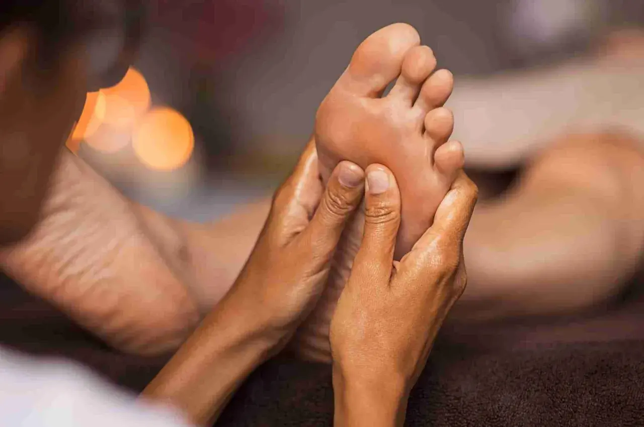 Mani esperte eseguono un rilassante foot massage, sciogliendo tensioni e donando benessere.