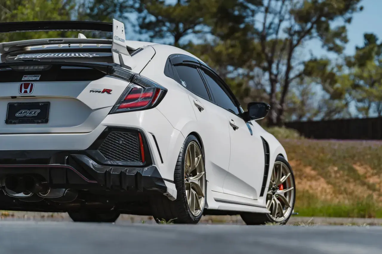 Weißer Honda Civic Type R 2018 mit goldenen Felgen und großem Heckspoiler, bereit für die Rennstrecke.