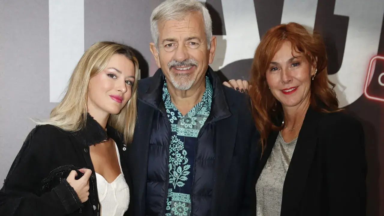 Carlos Sobera posa con sus hijos, una joven rubia y una mujer pelirroja, sonriendo a la cámara.
