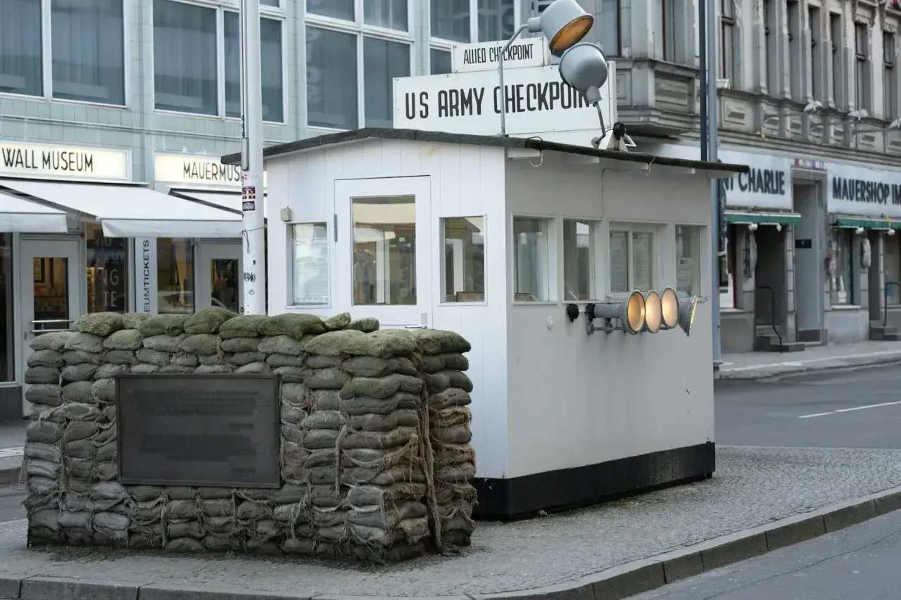 Checkpoint Charlie, dawne miejsce kontroli granicznej, z workami z piaskiem i tablicą pamiątkową.