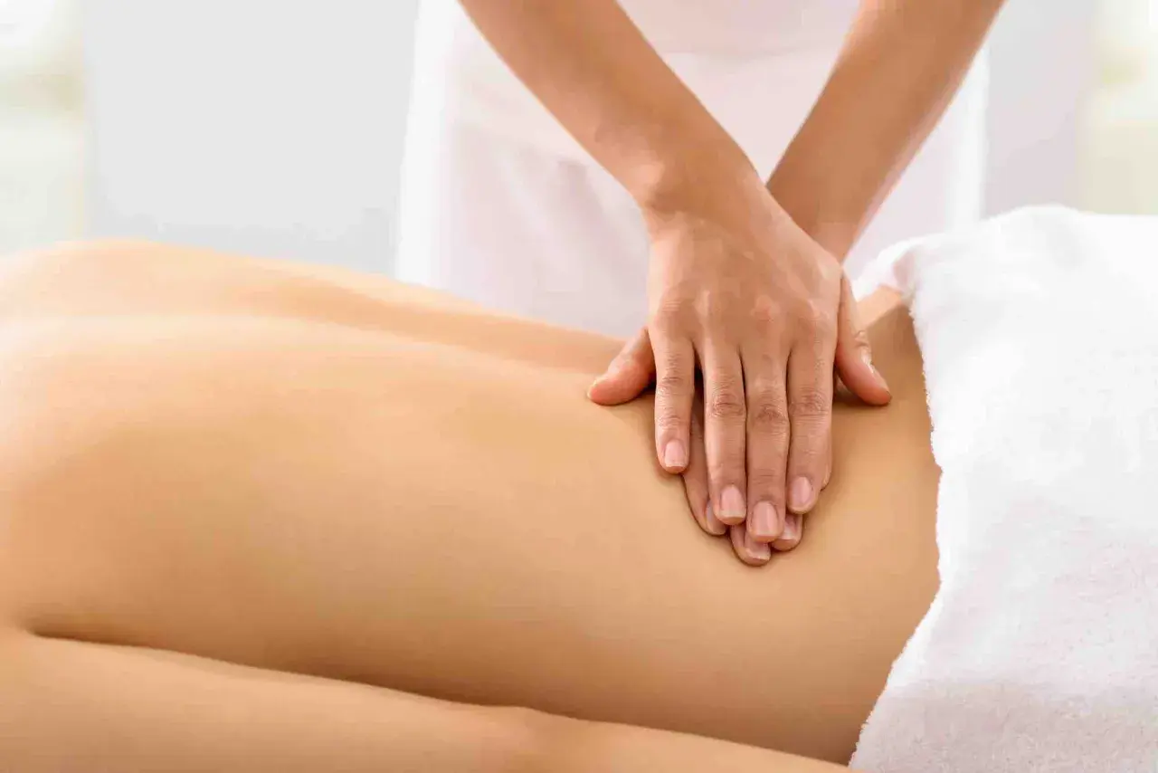 Mains expertes prodiguant un massage mal de dos apaisant, soulageant les tensions et apportant une détente profonde.