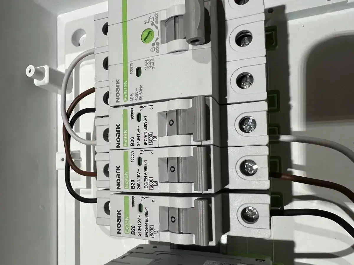 Budowa przewodu elektrycznego: zabezpieczenia nadprądowe Noark i podłączone przewody w rozdzielnicy.