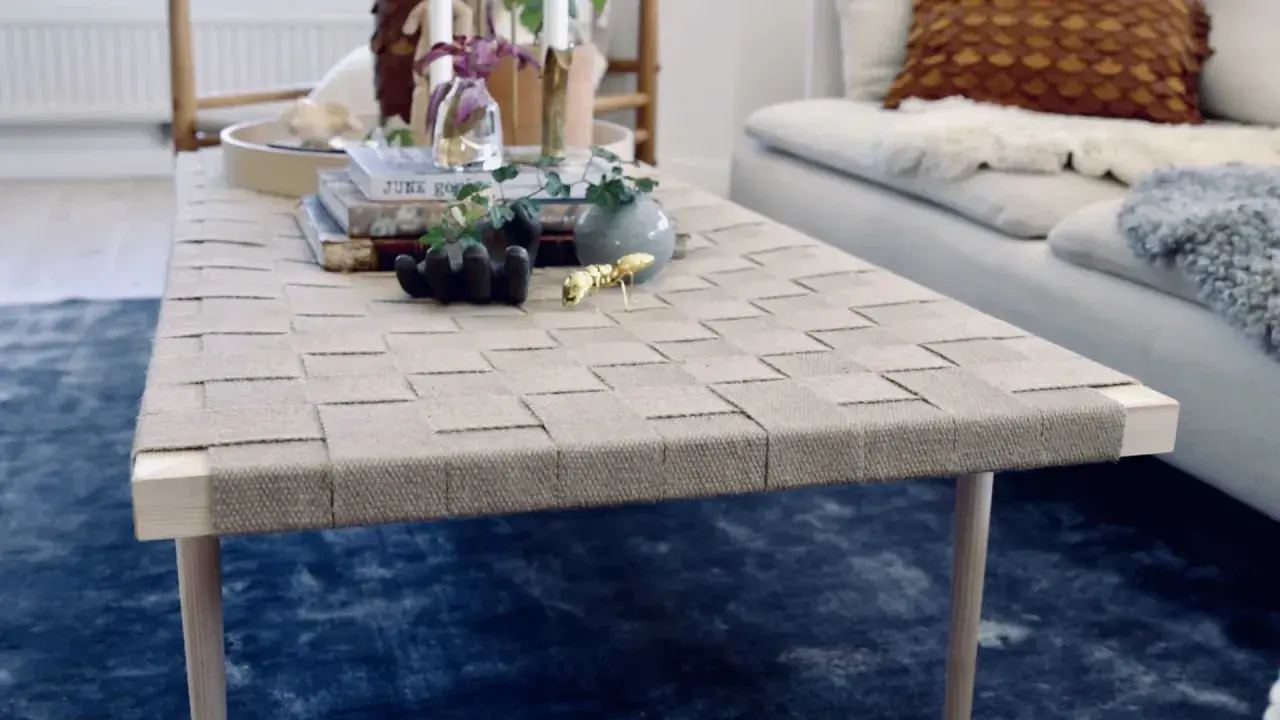Ett unikt diy soffbord med flätad topp och träben. Prydnader som en guldfärgad myra och en liten vas ger liv åt bordet.