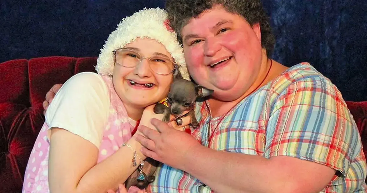 Gypsy Rose Blanchard i jej matka, Dee Dee, uśmiechają się do aparatu, trzymając małego psa.