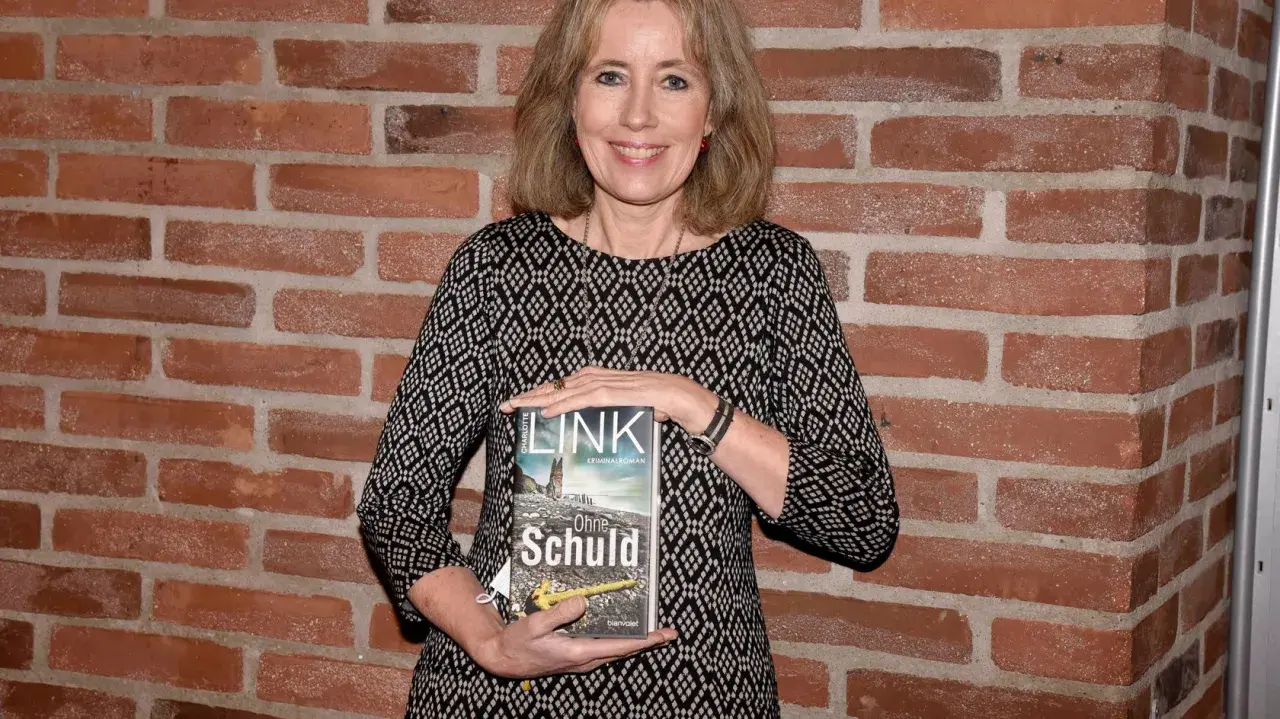 Eine Frau hält das Buch "Ohne Schuld" aus der kate-linville-reihe.