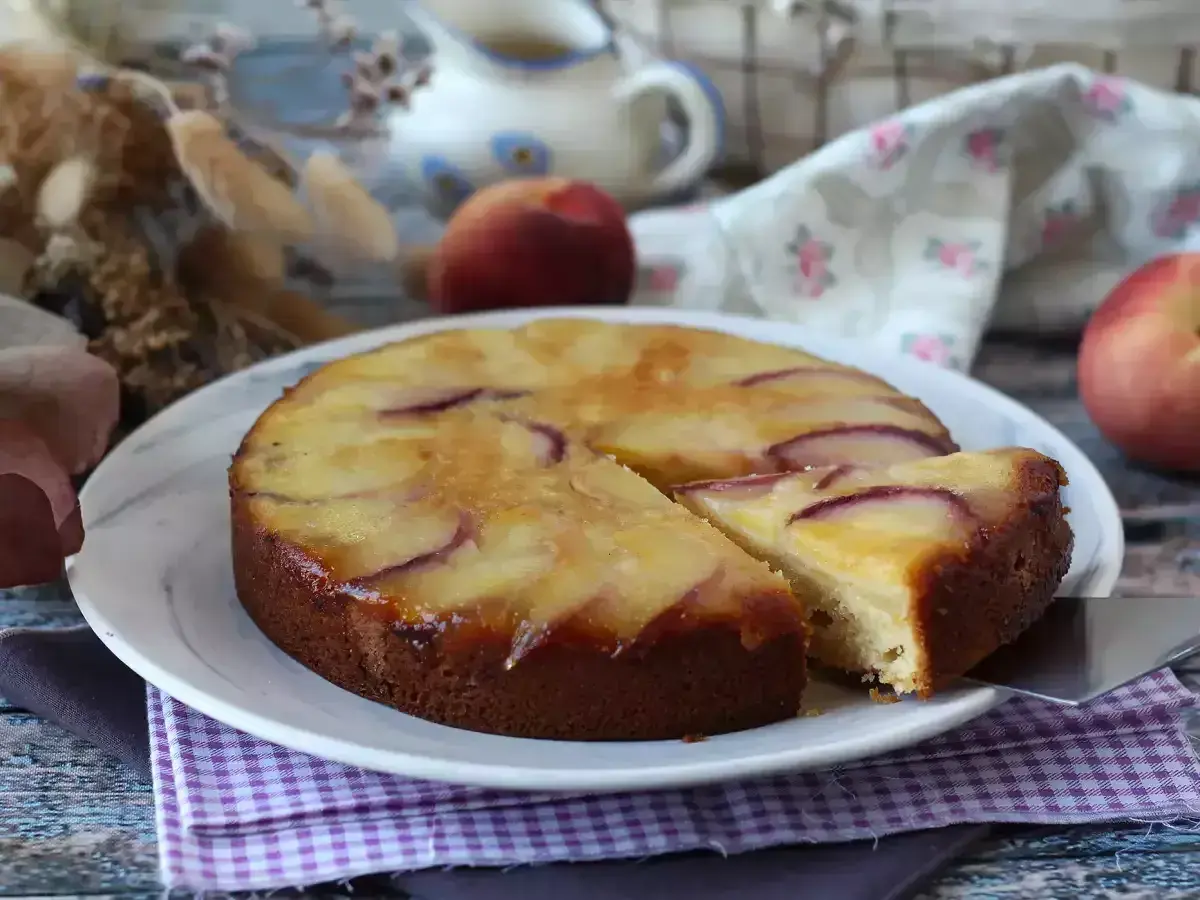 Deliziosa torta di pesche rovesciata, con fette di pesca caramellate sulla superficie dorata e soffice impasto.