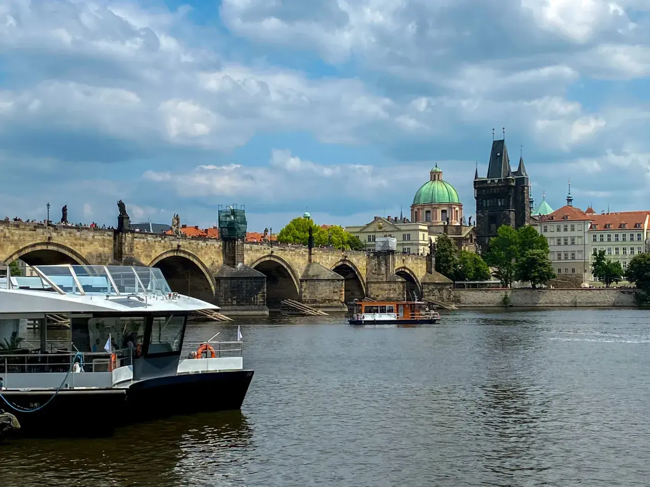 Rejs po Wełtawie czy warto? Widok na Most Karola z łodzią turystyczną.
