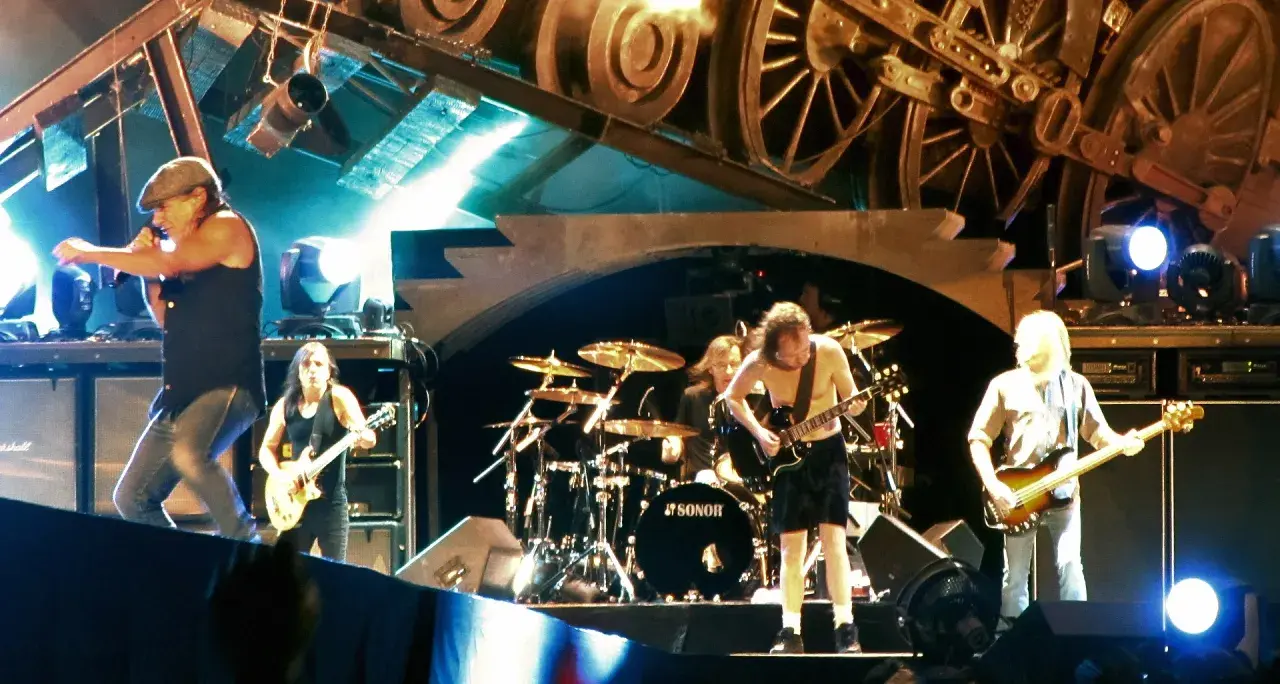 Zespół na scenie, wokalista z mikrofonem, gitarzyści i perkusista. To ich autostrada do piekła, pełna rock and rolla.