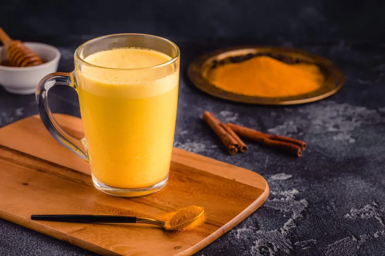 Goldene Kurkuma Milch mit Zimt und Honig. Die Kurkuma Milch Wirkung ist bekannt für ihre entzündungshemmenden Eigenschaften.