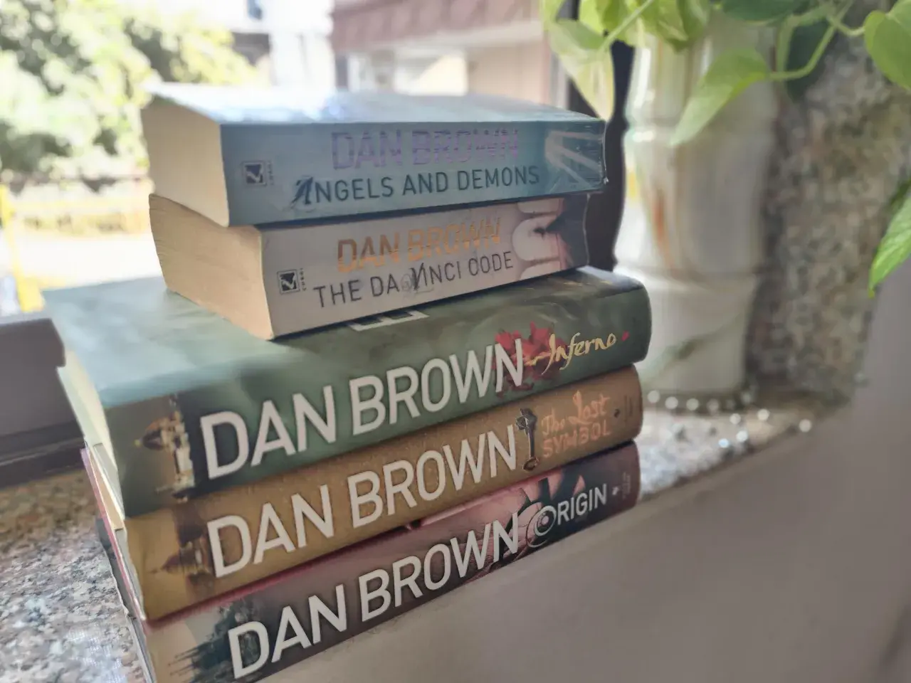 Stapel von Dan Brown Büchern: "Angels and Demons", "The Da Vinci Code", "Inferno", "The Lost Symbol" und "Origin".