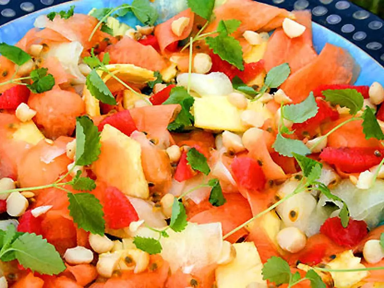 En färgglad melonsallad med ananas, passionsfrukt och nötter, perfekt som melonsallad till grillat.