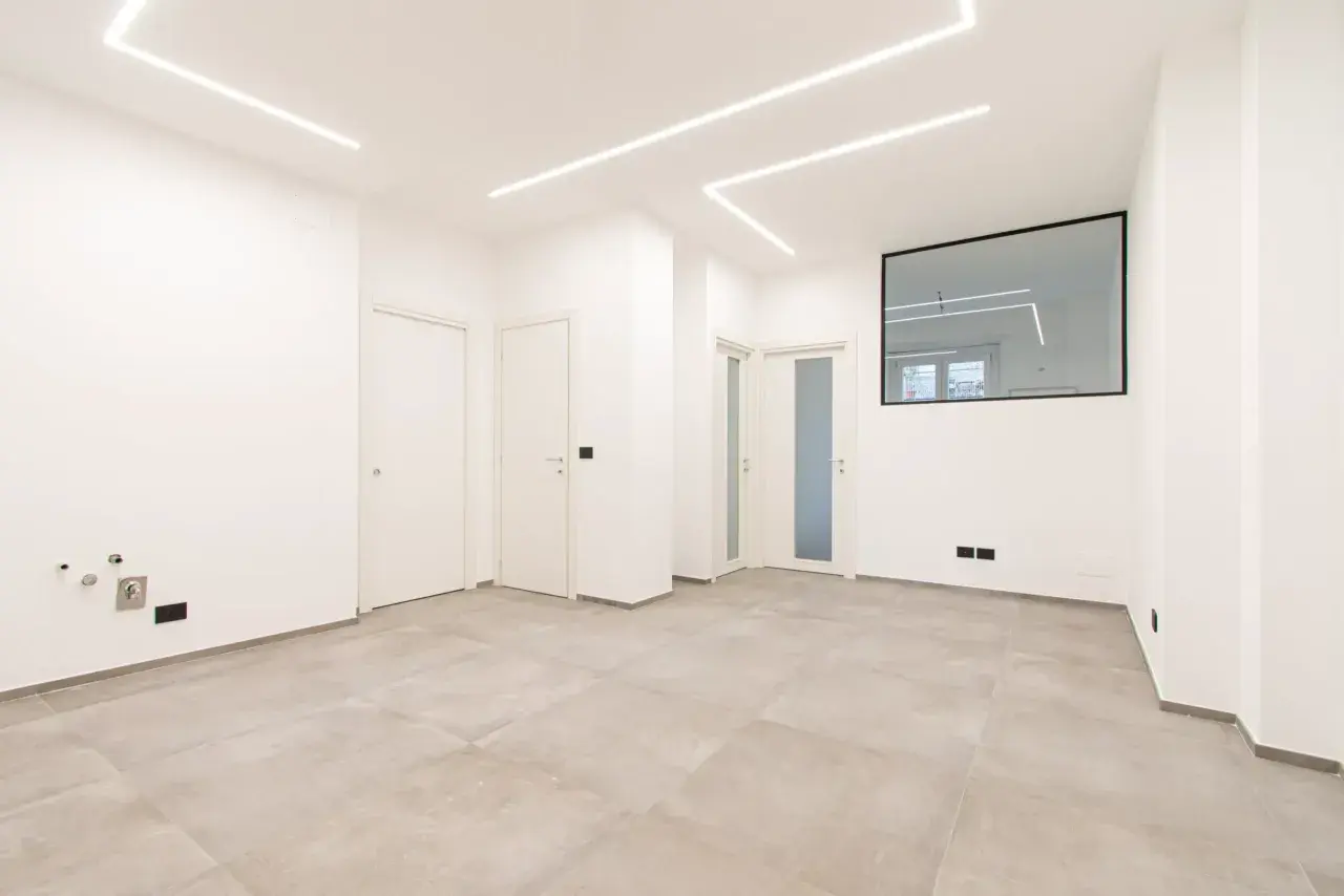 Interno moderno con pavimenti chiari, porte bianche e luci a led sul soffitto. Ideale per chi deve ristrutturare casa e cerca un ambiente luminoso e pulito.