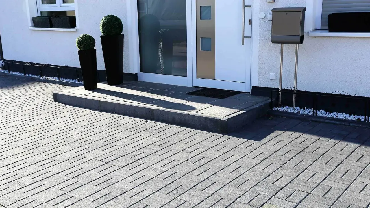 Nowoczesne aranżacje kostka brukowa wzory tworzą elegancki podjazd i schody przed domem.