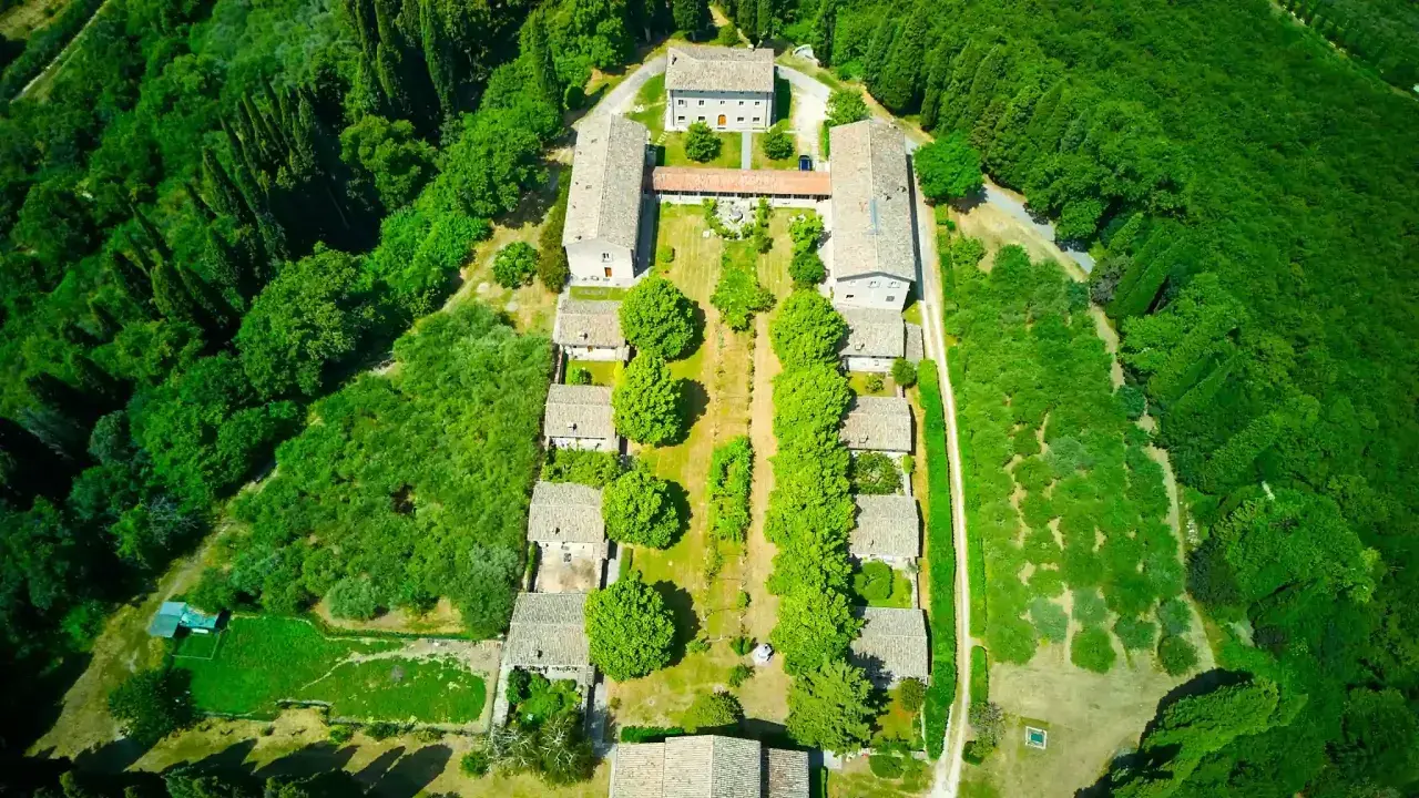 Vista aerea dell'eremo di San Giorgio, un complesso di edifici circondato da un rigoglioso bosco.