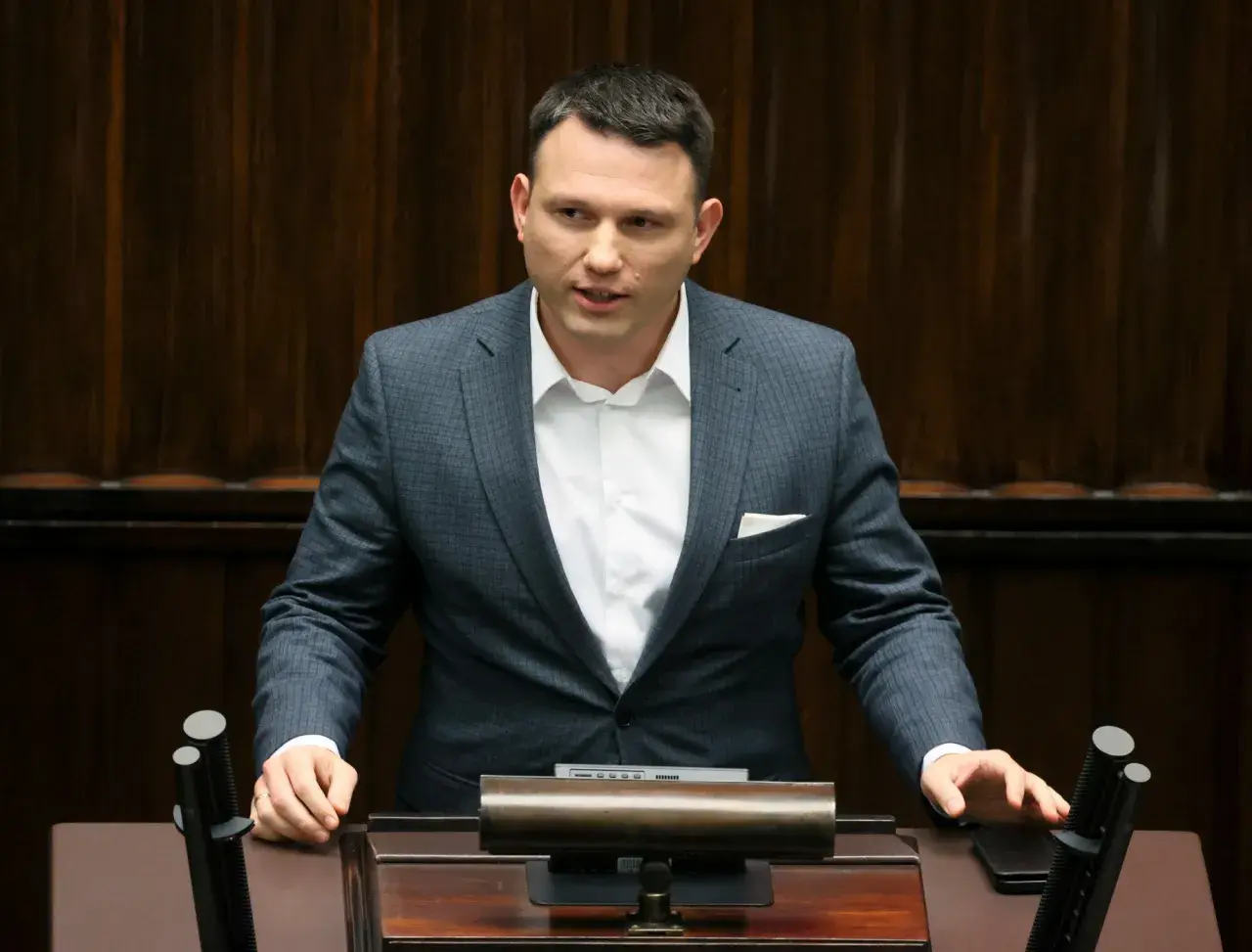 Sławomir Mentzen w garniturze przemawia, zastanawiając się, czy Sławomir Mentzen wykorzystuje AI do pisania swoich postów w kampanii prezydenckiej.