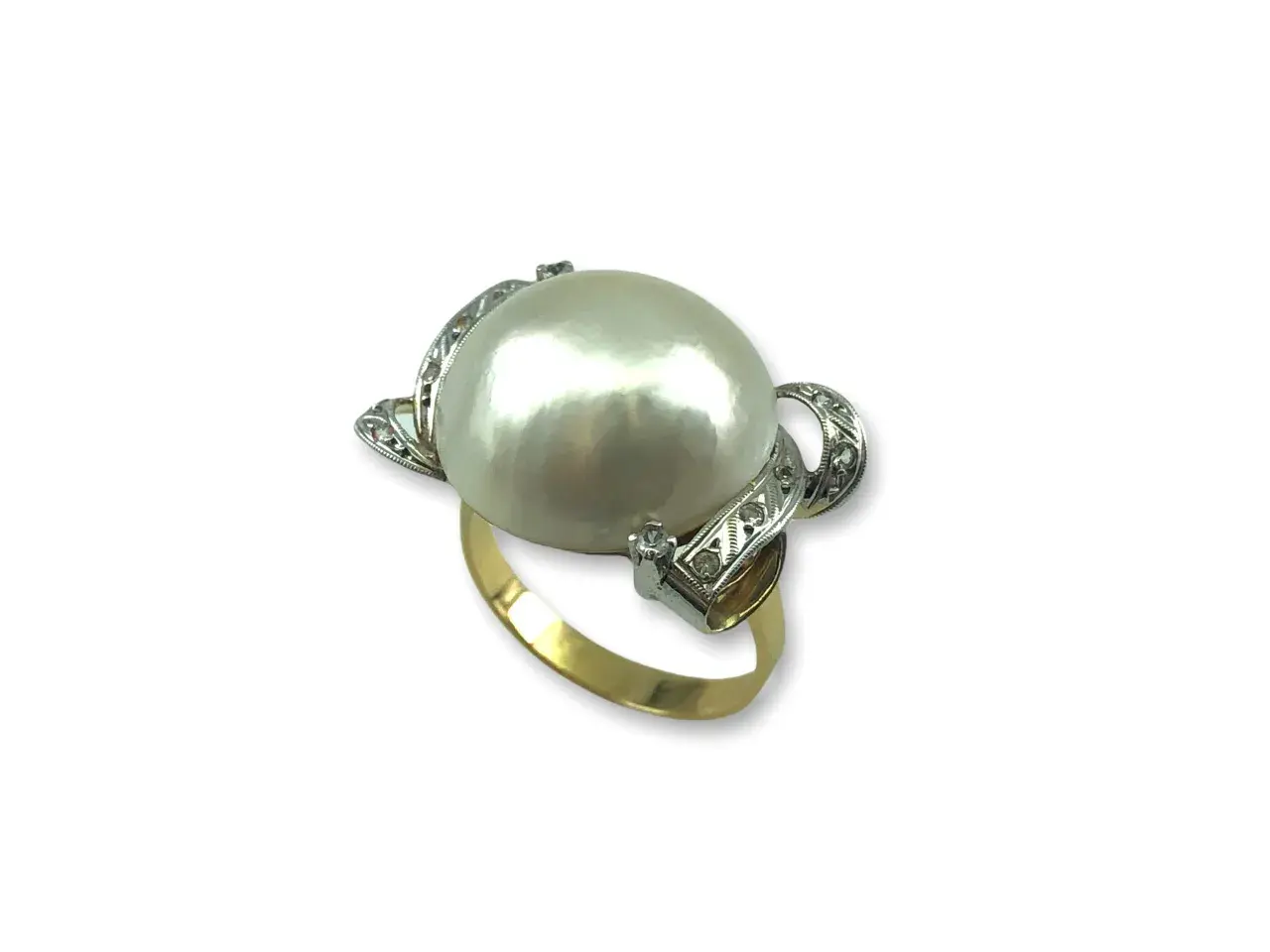 Anillo de oro con un gran anillo perla japonesa central, rodeado de pequeños diamantes incrustados en filigrana de plata.